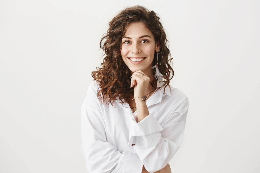 Woman wearing a white shirt against a plain background